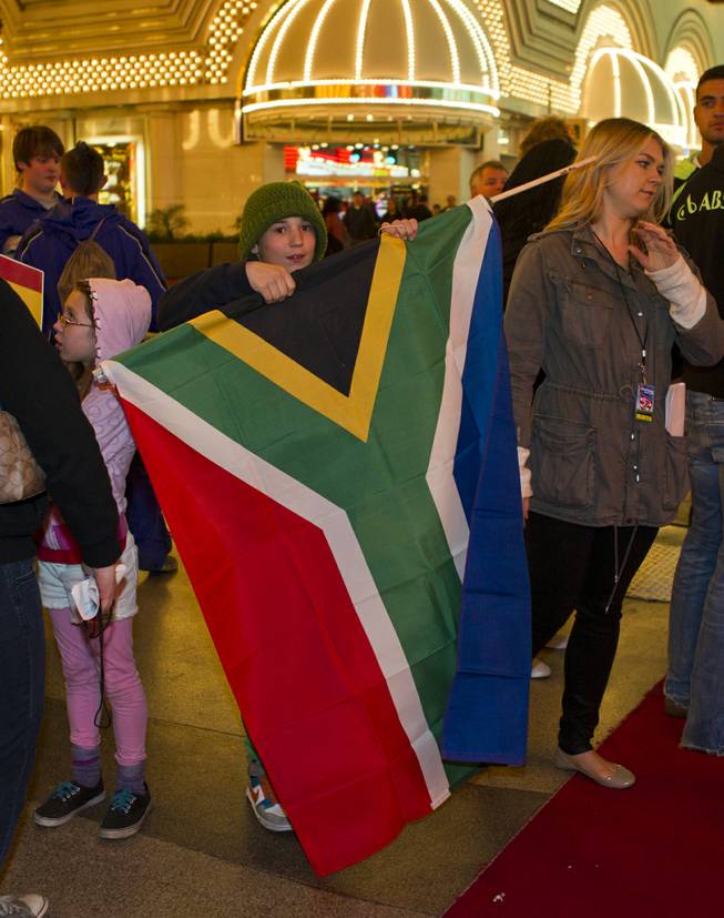 Jackson Bourgon, 11, of Las Vegas unfurls the S. Africa flag he will carry at the opening ceremonies and parade for the USA Sevens International Rugby Tournament  held at the Fremont Street Experience on Thursday, Jan. 23, 2014.